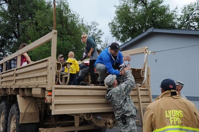 Residents being helped onto a National Guard truck by soldiers and a Lyons firefighter during the 2013 evacuation