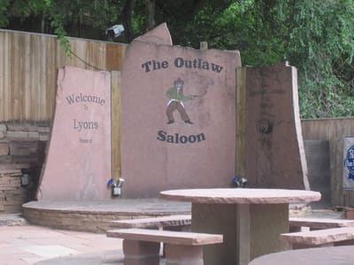 Carved slabs of Lyons sandstone standing as a sign and windbreak on a Main Street patio